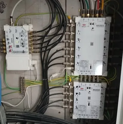 A head-end panel of multiswitches and amplifiers with tidy, labelled cabling.